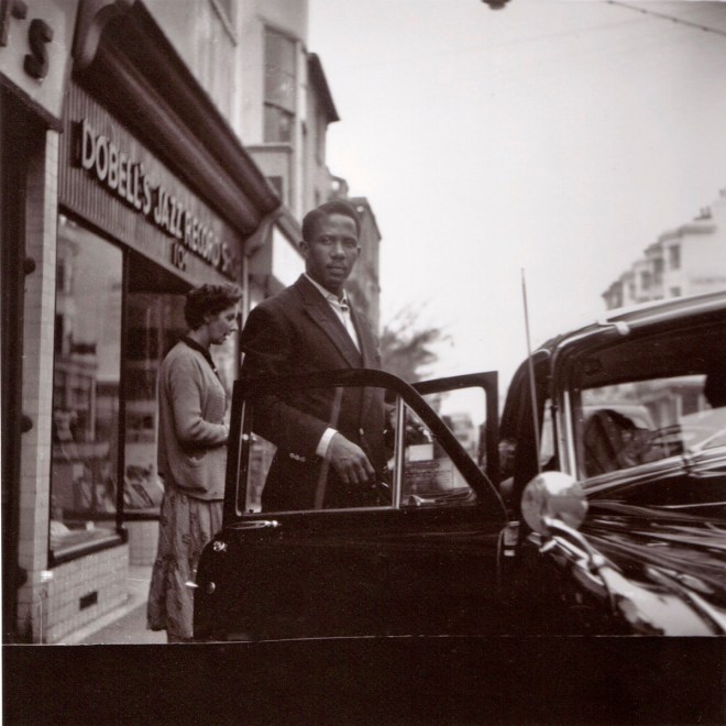 Unknown man outside shop, possibly Pete Martin’s wife Joyce behind him.