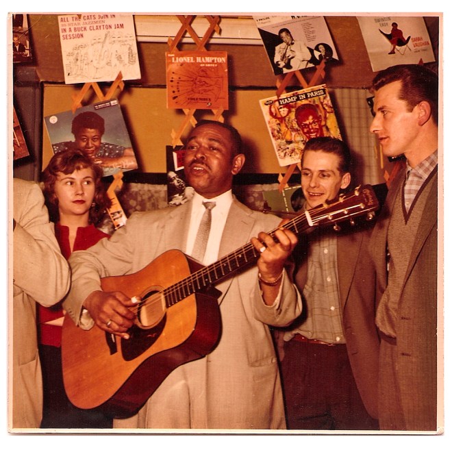 Ron & Mina Bowden and Bill look on as Brownie McGhee and Sonny Terry (cut off) play in the shop.